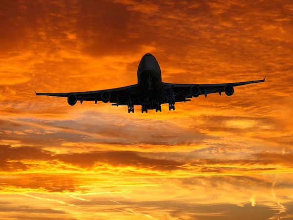 airplane flying at sunset